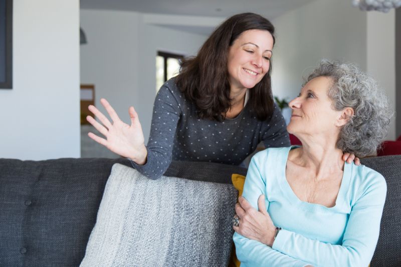 Smiling woman comforting her elderly mother